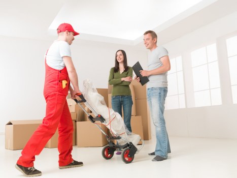 Specialist movers handling a piano through a residential property in Ilford